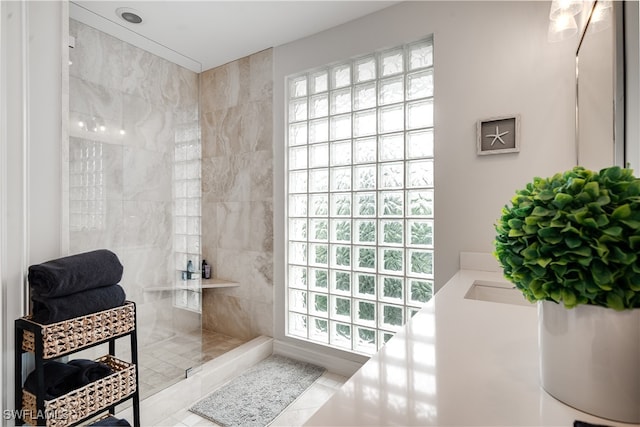 bathroom featuring tile patterned flooring and tiled shower