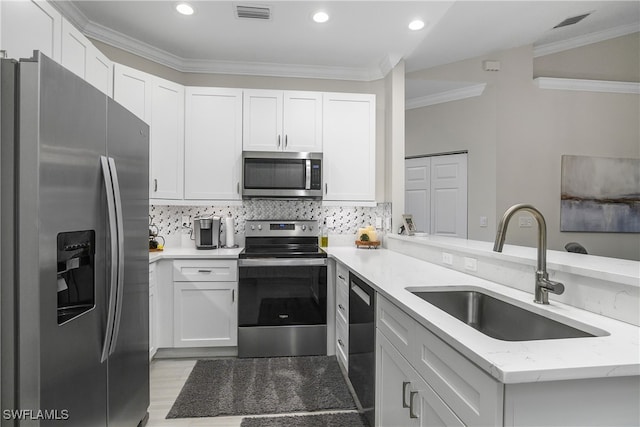 kitchen with crown molding, sink, kitchen peninsula, white cabinetry, and stainless steel appliances