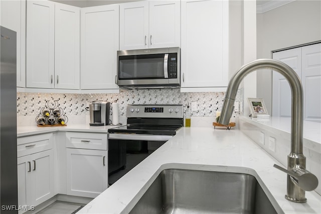 kitchen featuring white cabinets, light stone countertops, appliances with stainless steel finishes, and tasteful backsplash