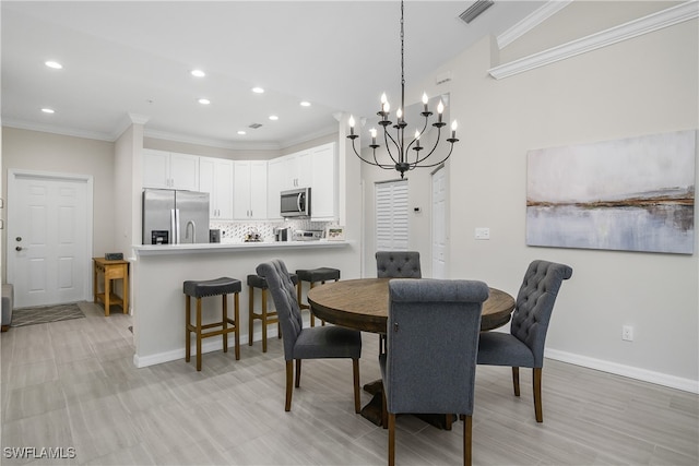 dining area with light hardwood / wood-style floors, ornamental molding, and a notable chandelier