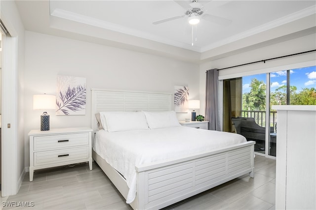 bedroom featuring ceiling fan, access to exterior, ornamental molding, and a tray ceiling