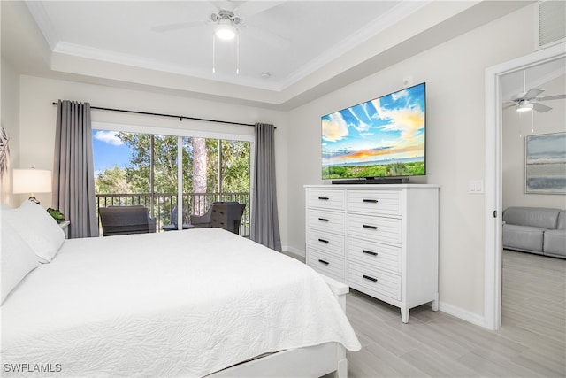 bedroom with access to outside, crown molding, ceiling fan, light wood-type flooring, and a tray ceiling