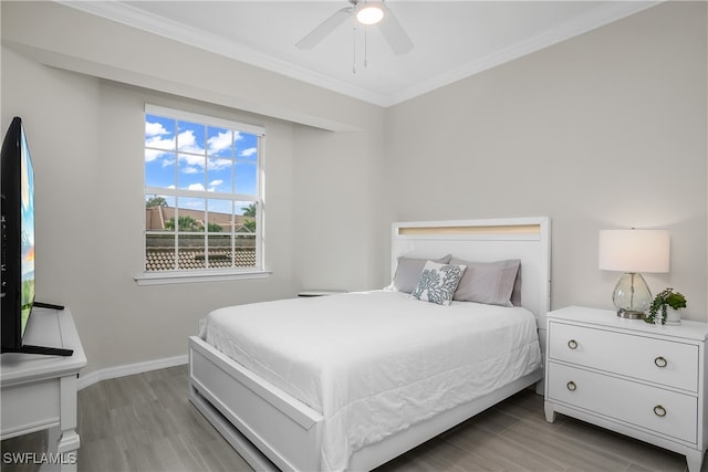 bedroom featuring ceiling fan, light hardwood / wood-style flooring, and ornamental molding