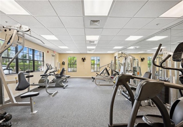 gym featuring a paneled ceiling and plenty of natural light