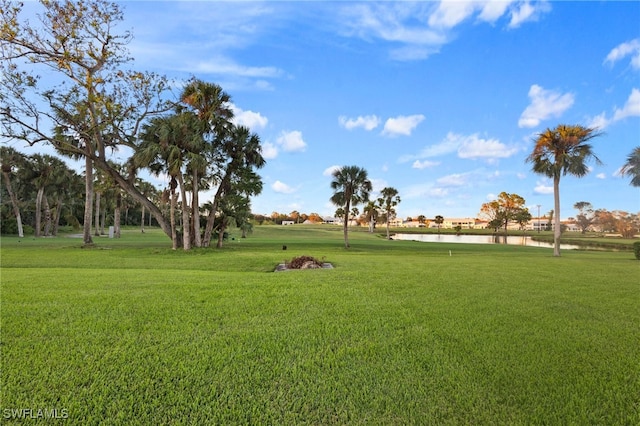 surrounding community with a water view and a yard