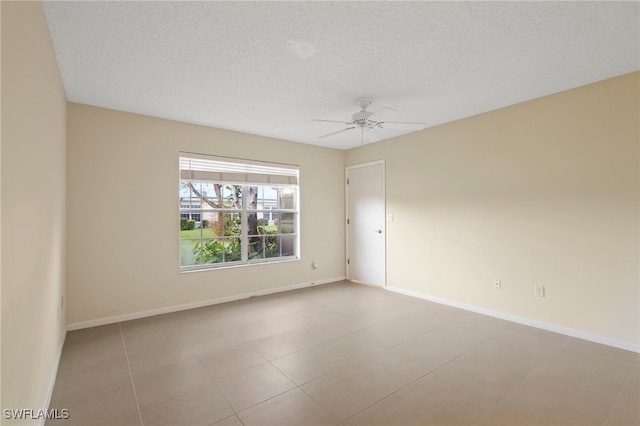 empty room with a textured ceiling, light tile patterned floors, and ceiling fan