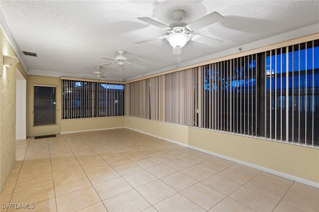 tiled spare room featuring ceiling fan and a textured ceiling