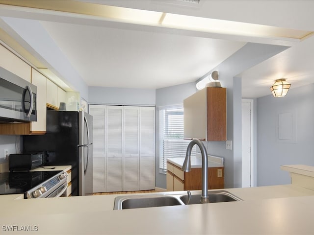 kitchen featuring electric range oven, sink, and cream cabinets