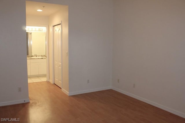 unfurnished room featuring wood-type flooring and sink