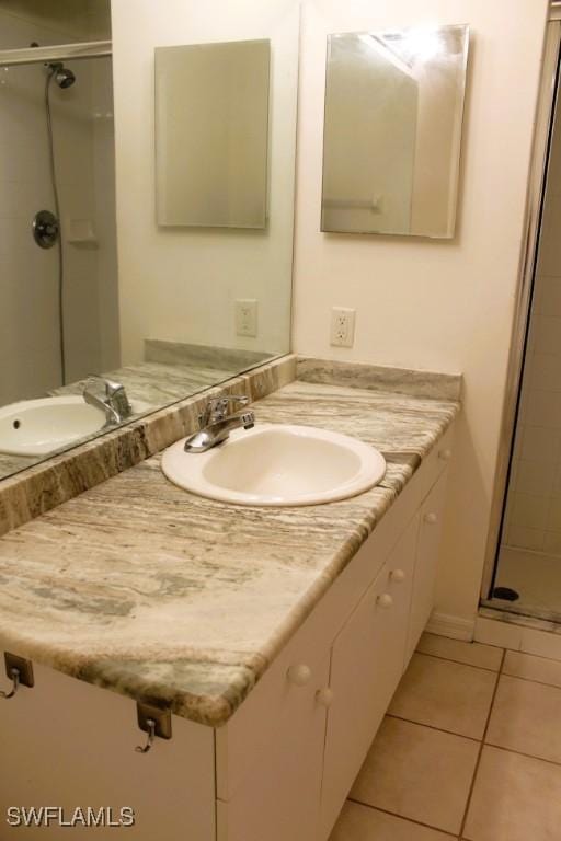 bathroom with tile patterned floors, vanity, and a shower with door