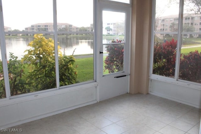 unfurnished sunroom featuring a water view and plenty of natural light