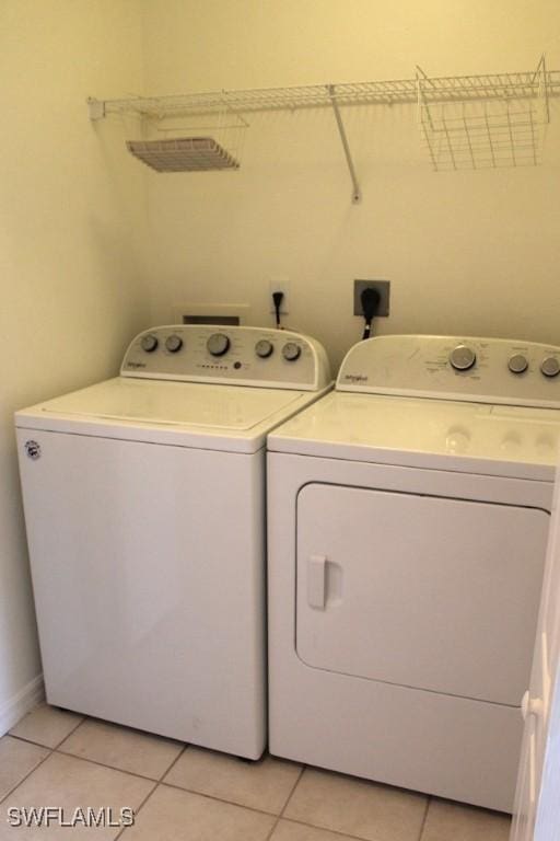 washroom with light tile patterned flooring and washing machine and clothes dryer