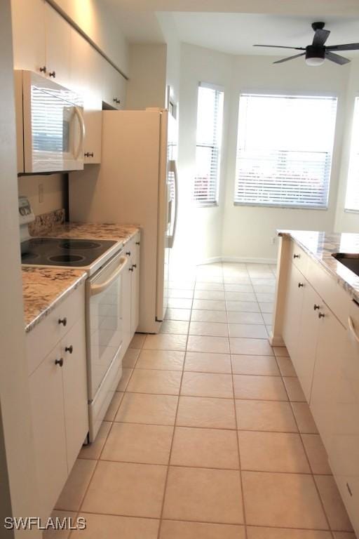 kitchen featuring white cabinetry, light stone countertops, white appliances, ceiling fan, and light tile patterned floors