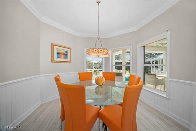 dining room with light hardwood / wood-style flooring and crown molding