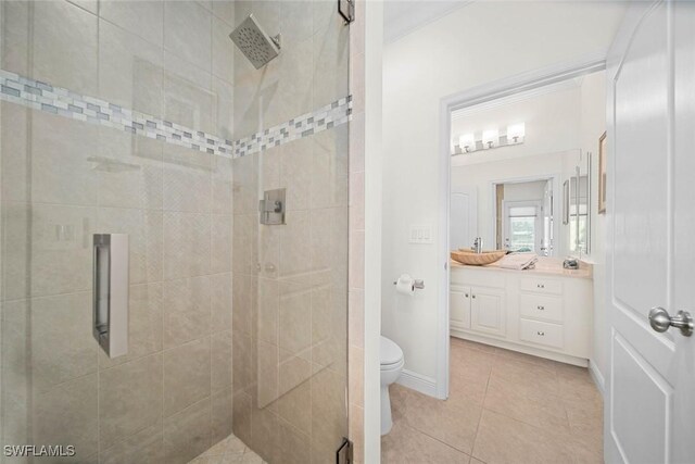 bathroom with toilet, a shower with door, vanity, and tile patterned flooring