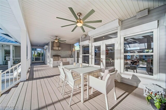 wooden terrace featuring ceiling fan and exterior kitchen