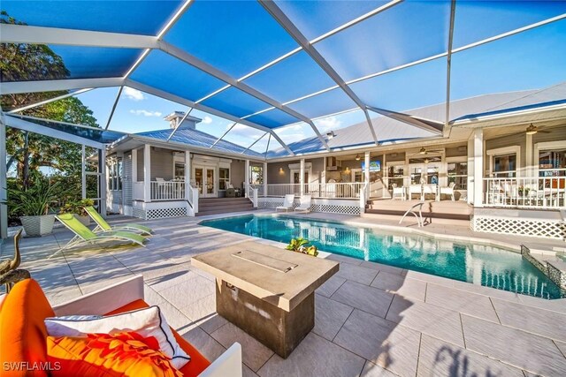 view of swimming pool with french doors, a patio, ceiling fan, and a lanai