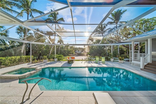 view of swimming pool with glass enclosure, a patio area, and an in ground hot tub