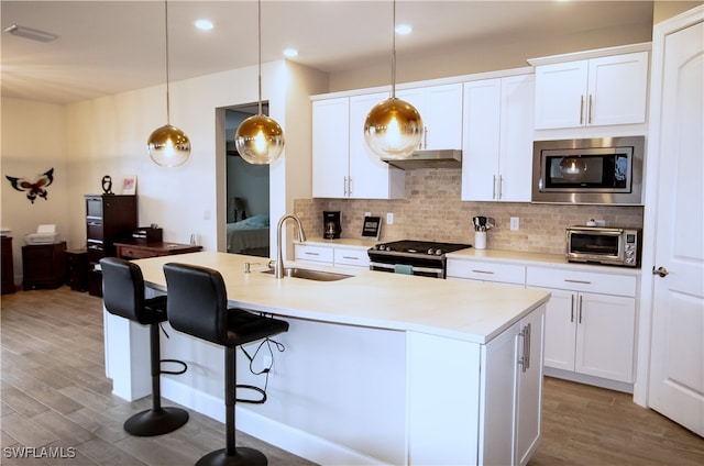 kitchen with stainless steel appliances, sink, and white cabinets