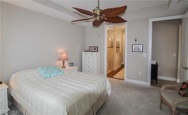 bedroom with ensuite bath, light carpet, and ceiling fan