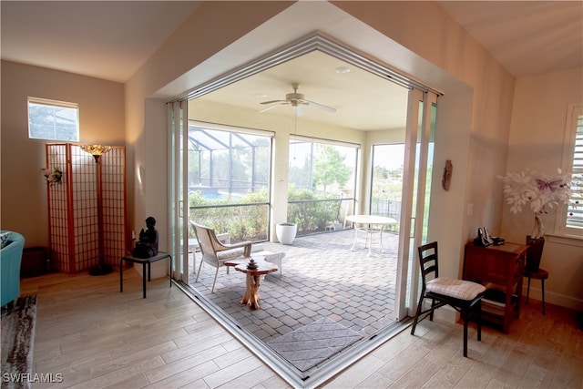 doorway to outside with a wealth of natural light, light hardwood / wood-style flooring, and ceiling fan