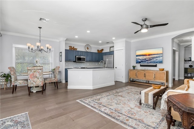 living room with ceiling fan with notable chandelier, light wood-type flooring, and crown molding