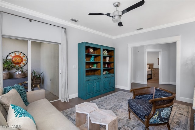 living area with dark hardwood / wood-style flooring, ceiling fan, and ornamental molding