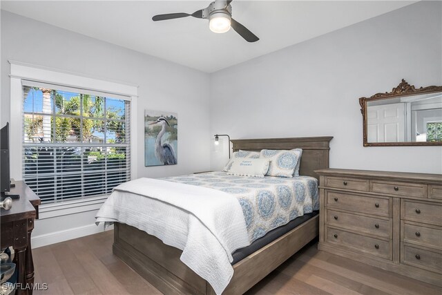 bedroom with dark hardwood / wood-style flooring and ceiling fan