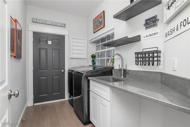 clothes washing area with dark hardwood / wood-style floors, sink, and washing machine and clothes dryer