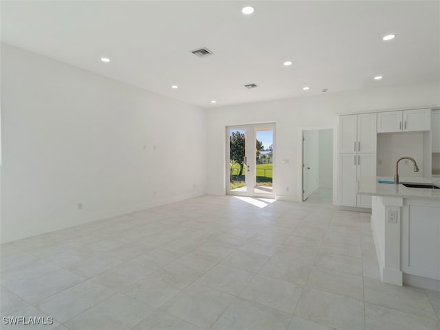 unfurnished living room with light tile patterned floors and sink