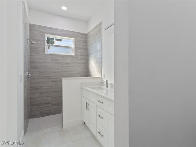 bathroom with a tile shower, tile patterned floors, and vanity