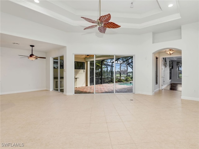 spare room featuring ornamental molding, ceiling fan, and a raised ceiling