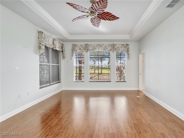 unfurnished dining area with crown molding, hardwood / wood-style flooring, and a raised ceiling