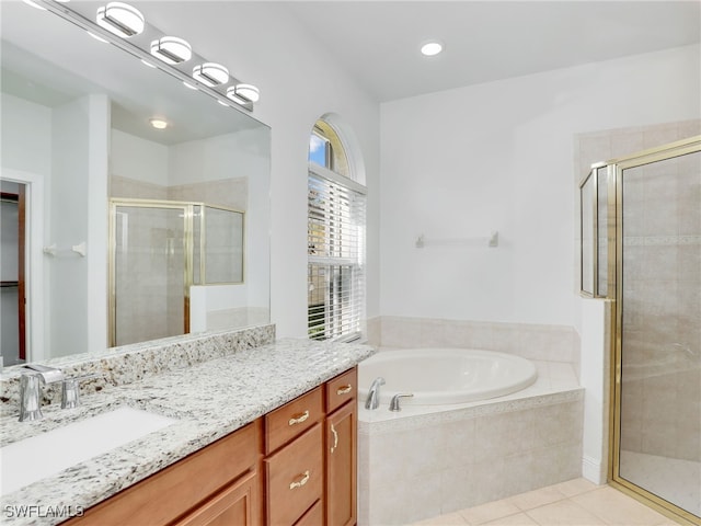 bathroom with vanity, tile patterned floors, and plus walk in shower