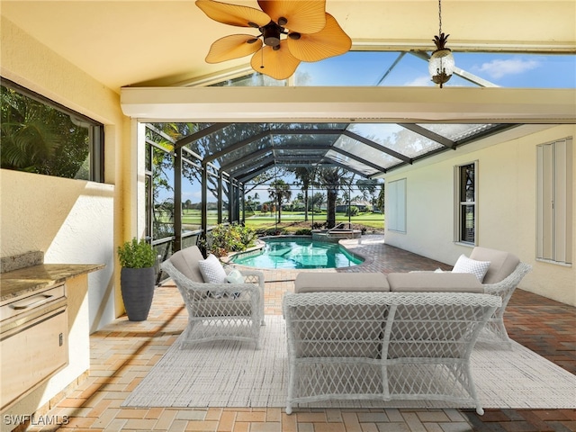 view of patio / terrace featuring outdoor lounge area, glass enclosure, and ceiling fan