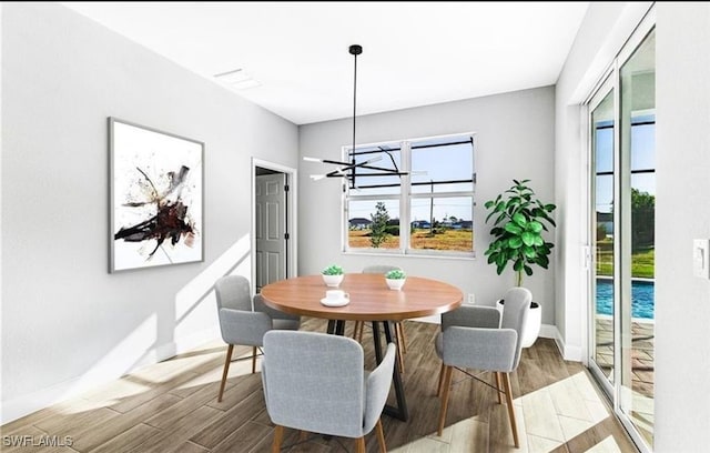 dining space with an inviting chandelier and hardwood / wood-style flooring