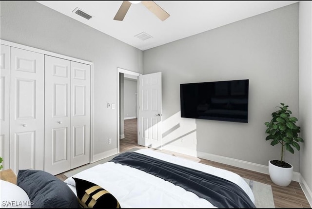 bedroom featuring hardwood / wood-style flooring, ceiling fan, and a closet