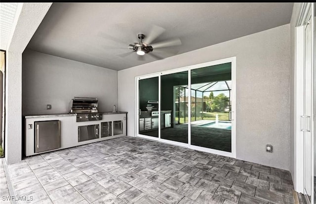 view of patio featuring grilling area, sink, an outdoor kitchen, and ceiling fan