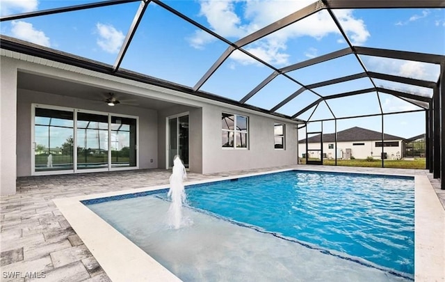 view of swimming pool featuring a patio area, a lanai, and ceiling fan