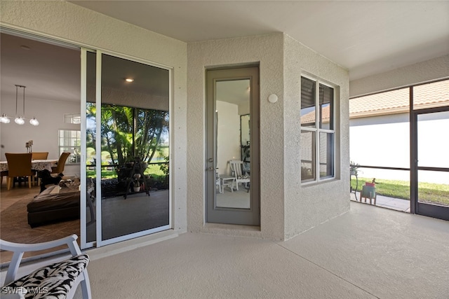 sunroom featuring a wealth of natural light and an inviting chandelier