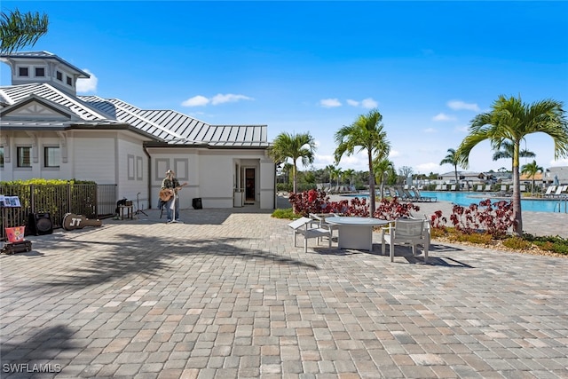 exterior space featuring a community pool, a water view, and a patio