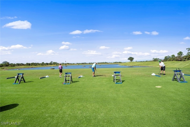 surrounding community with a water view and a yard