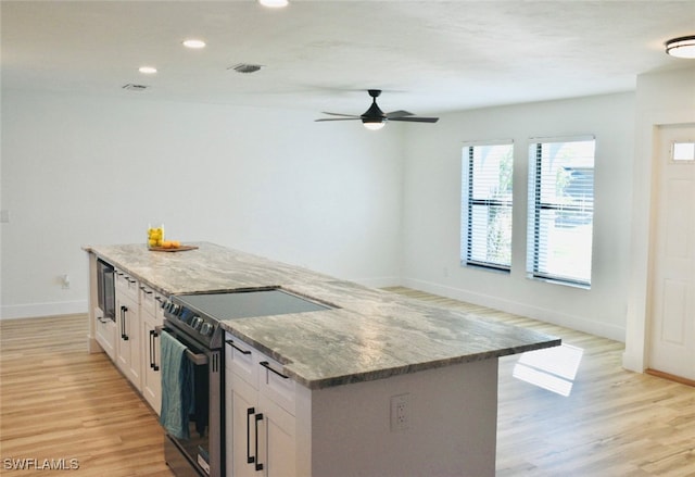 kitchen featuring light stone countertops, appliances with stainless steel finishes, light wood-type flooring, ceiling fan, and white cabinets