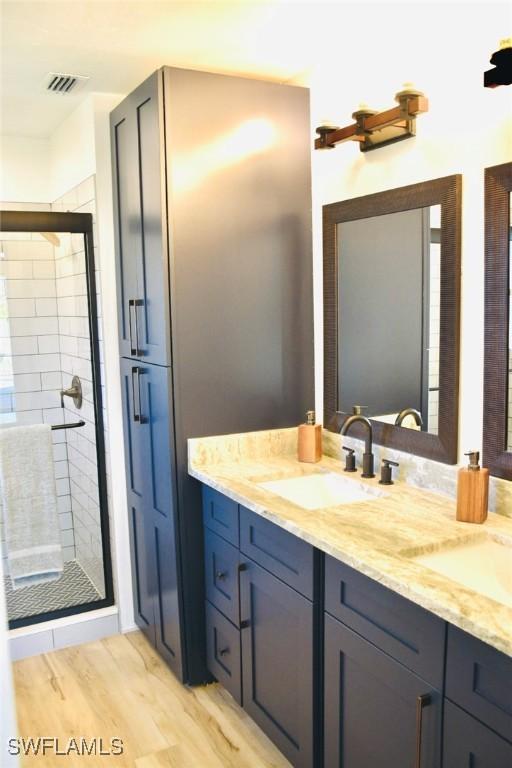 bathroom featuring vanity, wood-type flooring, and walk in shower