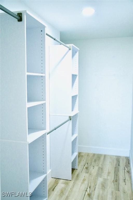 walk in closet with light hardwood / wood-style floors