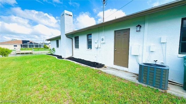 back of house with a yard and central AC unit