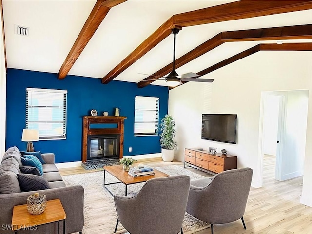 living room with ceiling fan, lofted ceiling with beams, and light wood-type flooring