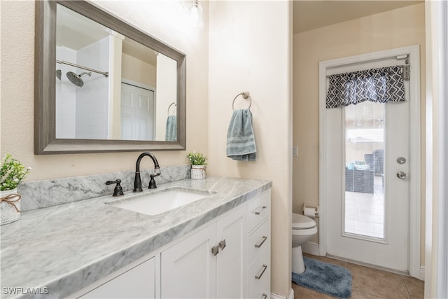 bathroom featuring toilet, vanity, and tile patterned flooring