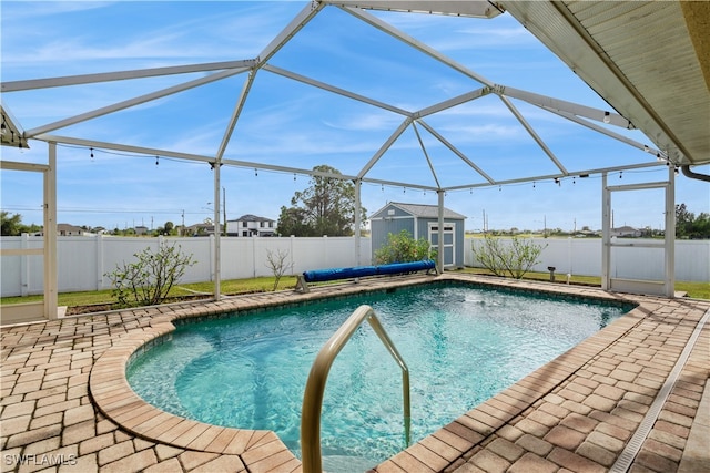 view of swimming pool featuring a patio area, a lanai, and a shed