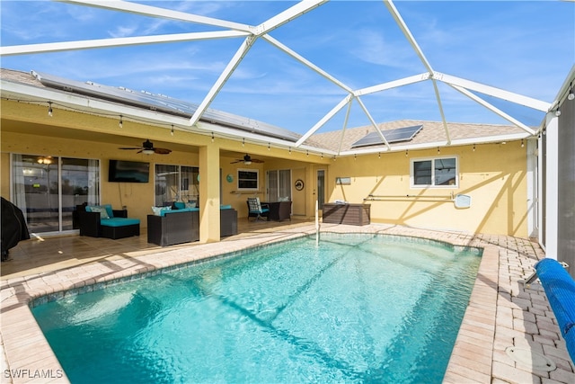 view of pool featuring glass enclosure, a patio, and ceiling fan